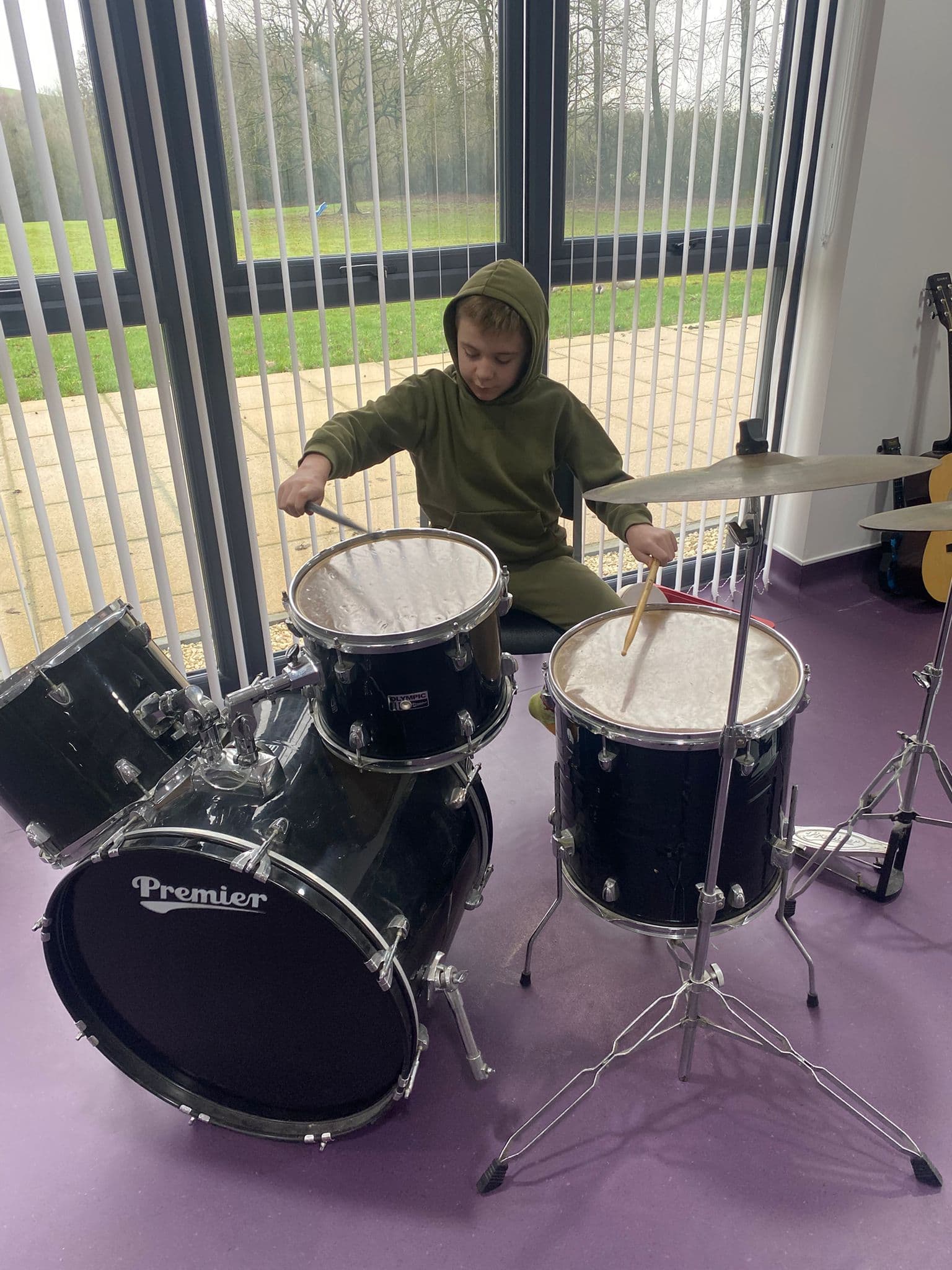 Child playing the drums during a music therapy session