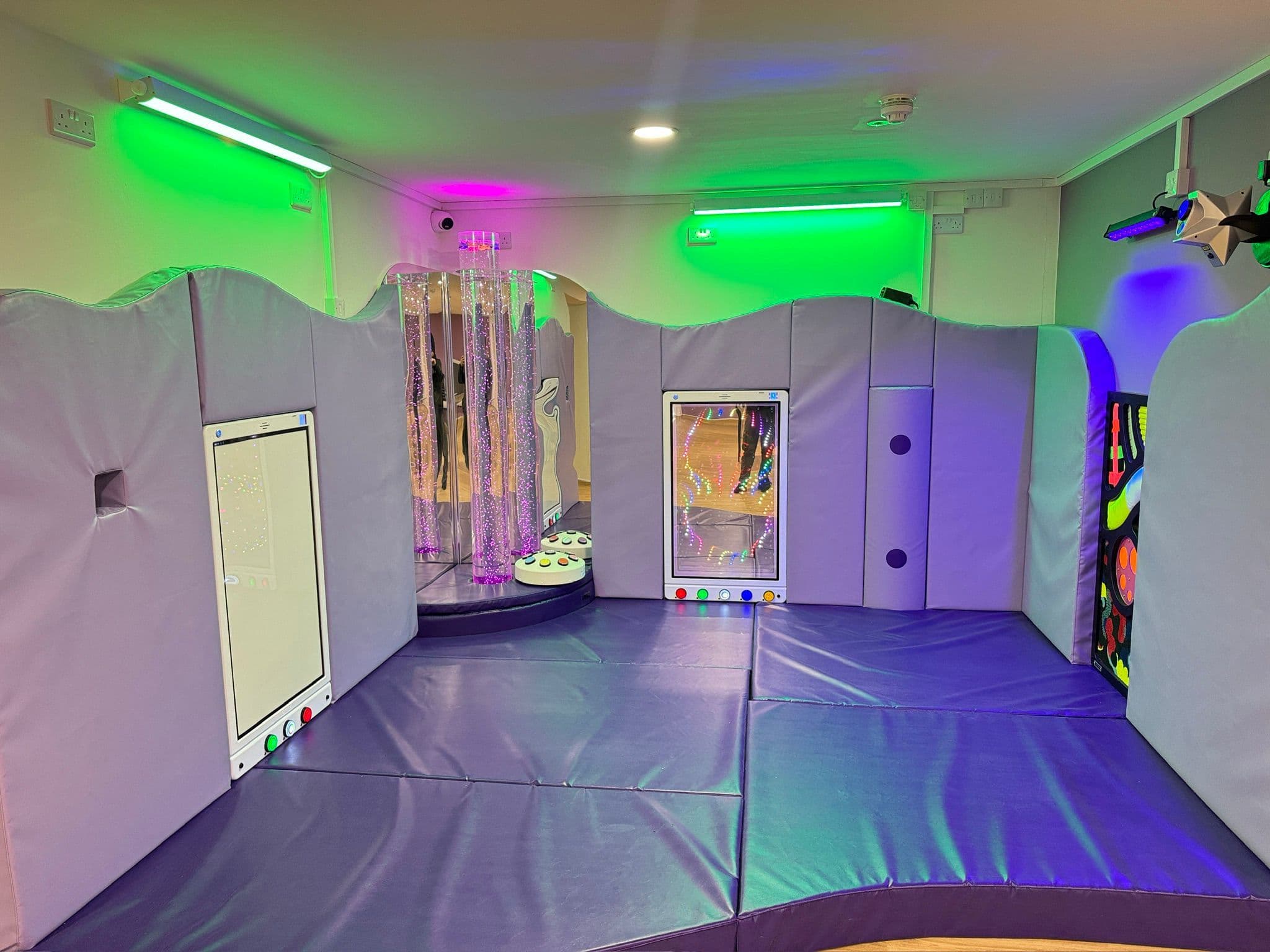 Sensory room with soothing green lighting for relaxation