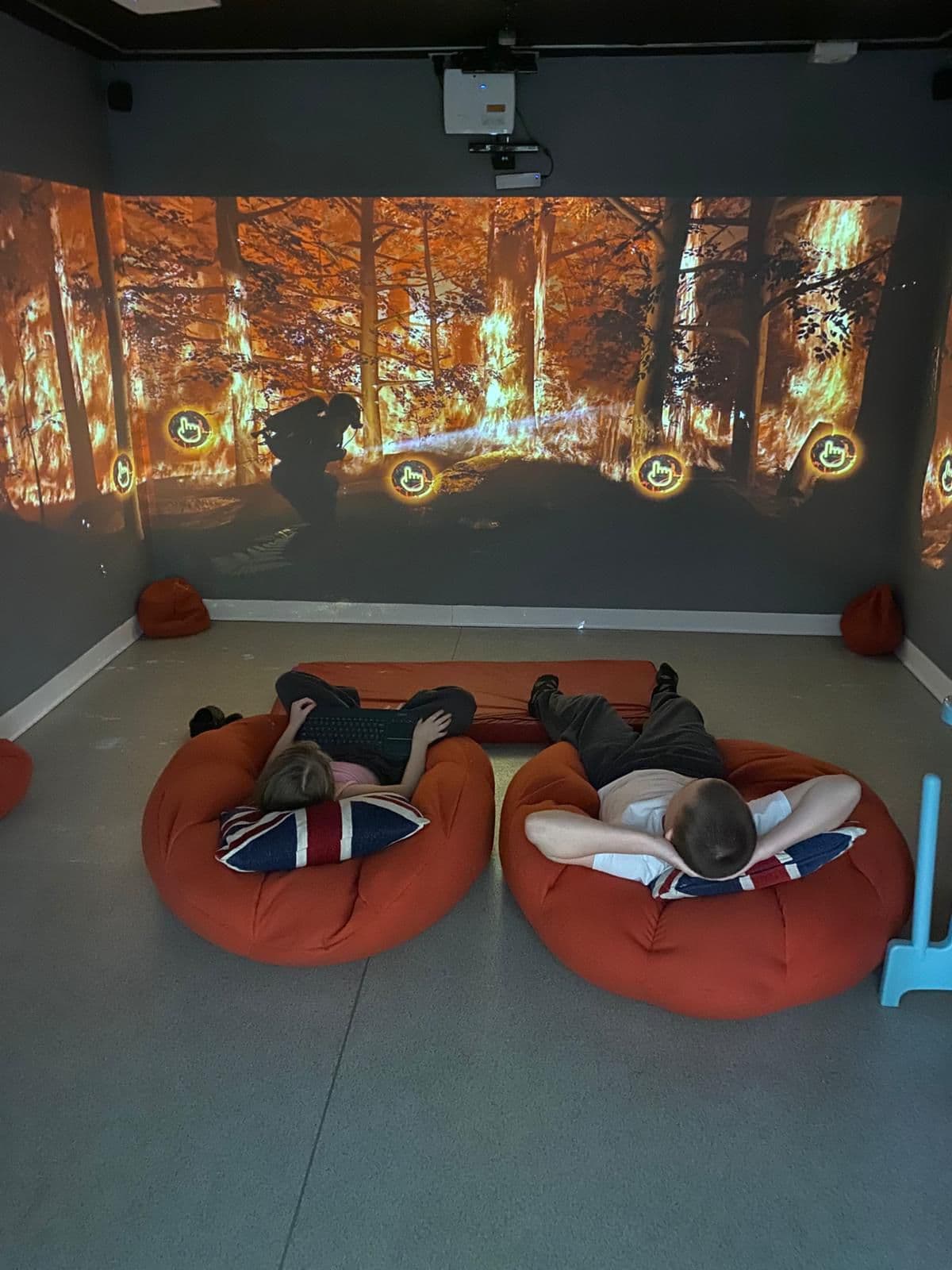 Children relaxing on beanbags watching an immersive forest projection