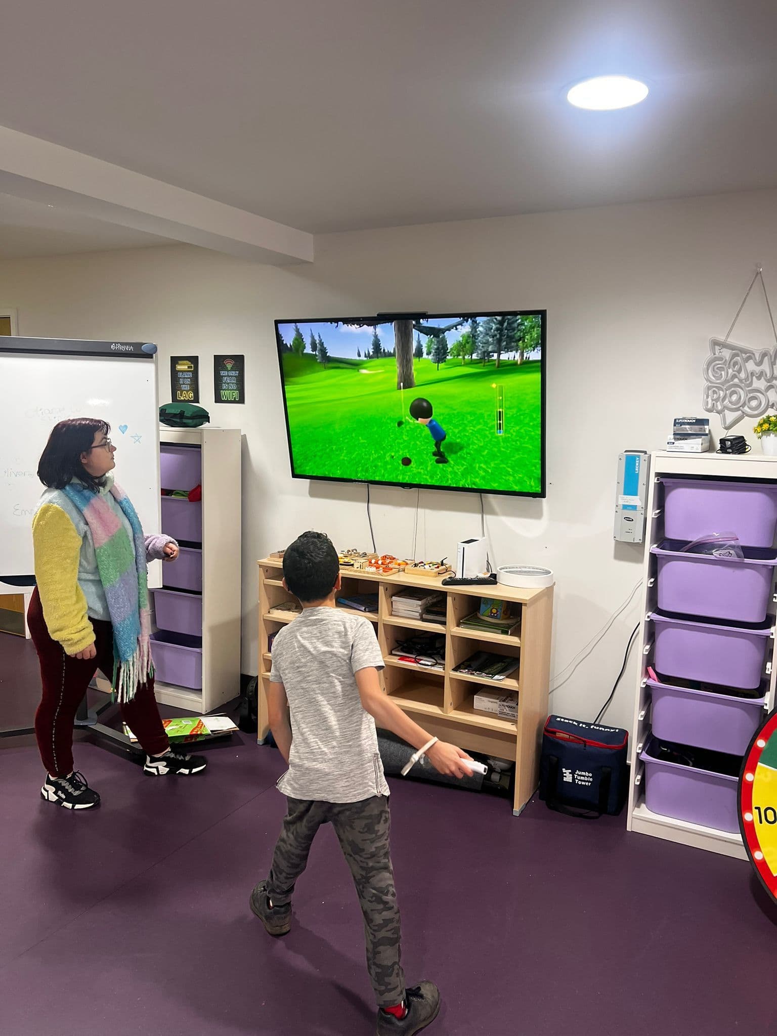 Children playing Wii Sports together with staff supervision