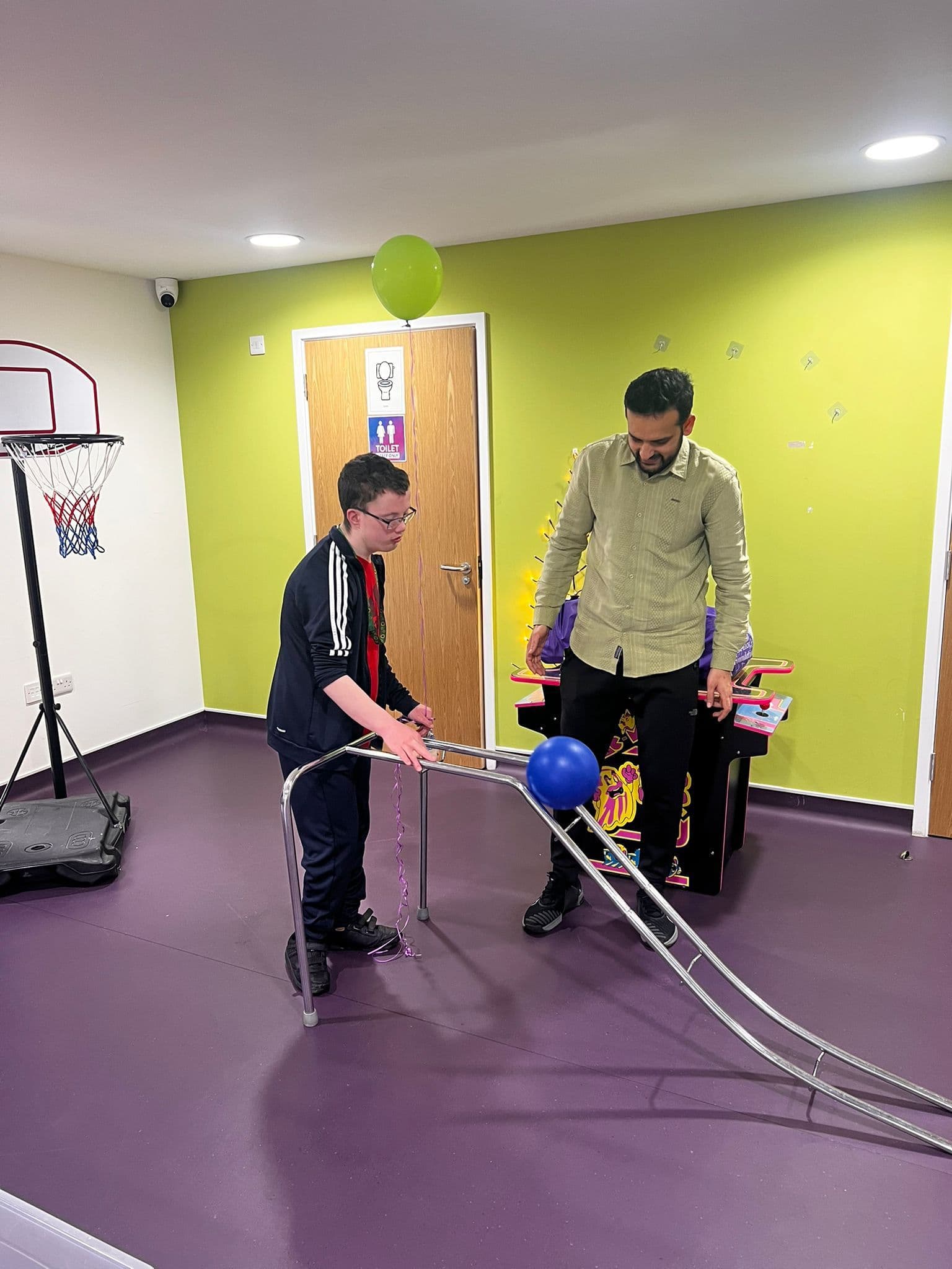 Staff member guiding a child through a developmental activity in the movement room